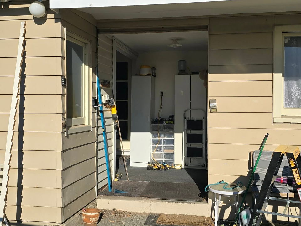 During: the old sliding door removed from a weatherboard wall, the opening ready for the new door