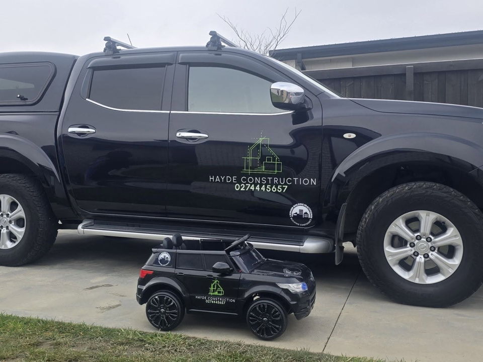The signwritten Hayde Construction ute parked on a driveway, Licensed Building Practitioner mark on the door