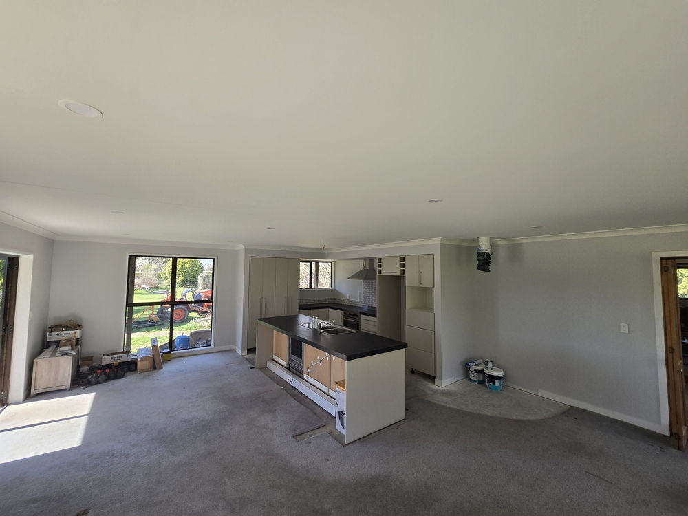 Freshly painted open-plan living area with a new kitchen and island going in, September 2026