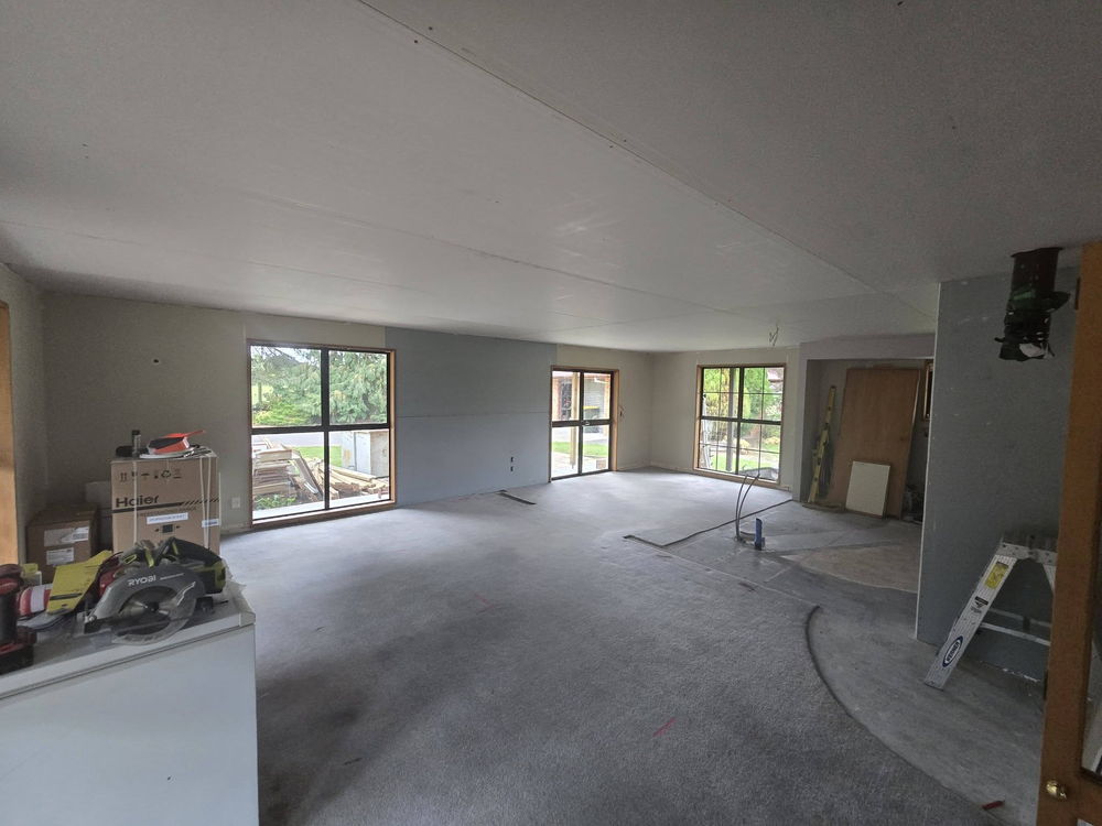 Open-plan living area newly lined and stopped, ready for the painters